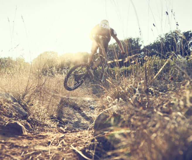 e-bike MTB. Andrea Garibbo e-bike enduro rider along the trails of Lerici under a worm summer afternoon light. Photographed at mid air through the bushes by David Umberto Zappa, portrait, commercial, editorial, sports photographer based in Italy. Andrea Garibbo, rider enduro di e-bike lungo i sentieri di Lerici avvolto dalla luce di un tardo pomeriggio estivo. Ritratto a mezz’aria dal fotografo pubblicitario, commerciale, ritrattista, sportivo David Umberto Zappa.