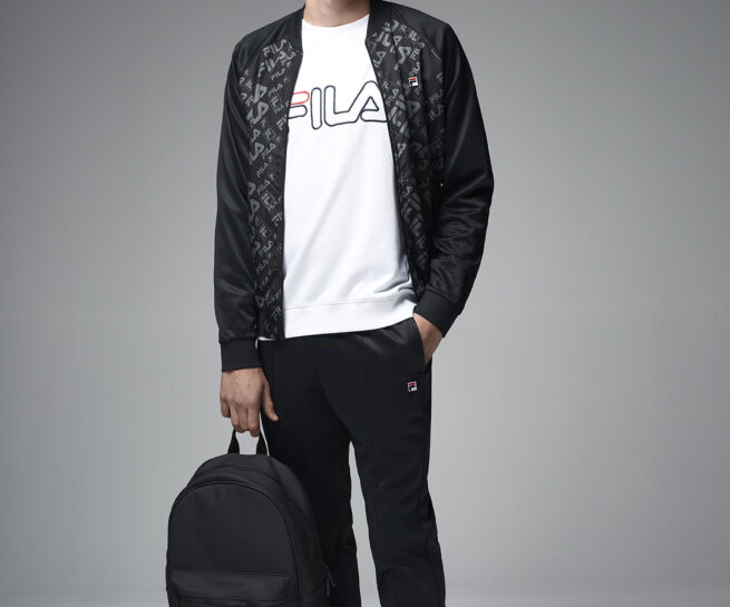 FILA CINA lookbook 2018. Full body portrait of young man in sweaters holding a backpack. Image shot by David Umberto Zappa, portrait, advertising, editorial photographer - duzimage / immagine di FILA CINA lookbook 2018. Giovane uomo indossa tuta da ginnastica tenendo in mano uno zaino nero. Immagine scattata da David Umberto Zappa fotografo ritrattista, commerciale, pubblicitario, editoriale.