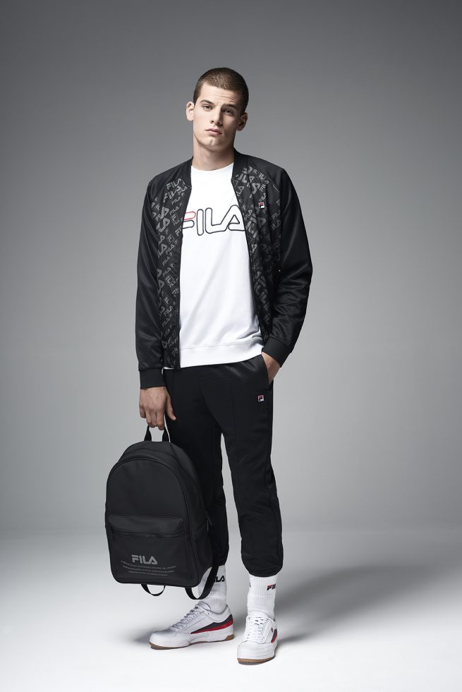 FILA CINA lookbook 2018. Full body portrait of young man in sweaters holding a backpack. Image shot by David Umberto Zappa, portrait, advertising, editorial photographer - duzimage / immagine di FILA CINA lookbook 2018. Giovane uomo indossa tuta da ginnastica tenendo in mano uno zaino nero. Immagine scattata da David Umberto Zappa fotografo ritrattista, commerciale, pubblicitario, editoriale.