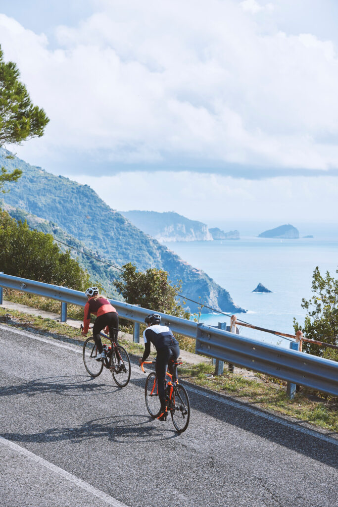 fotografia di ciclisti lungo strada litoranea in Provincia di La Spezia. Sulla sfondo Isola del Tino. fotografo sportivo duzimage di David Umberto Zappa, fotografo La Spezia