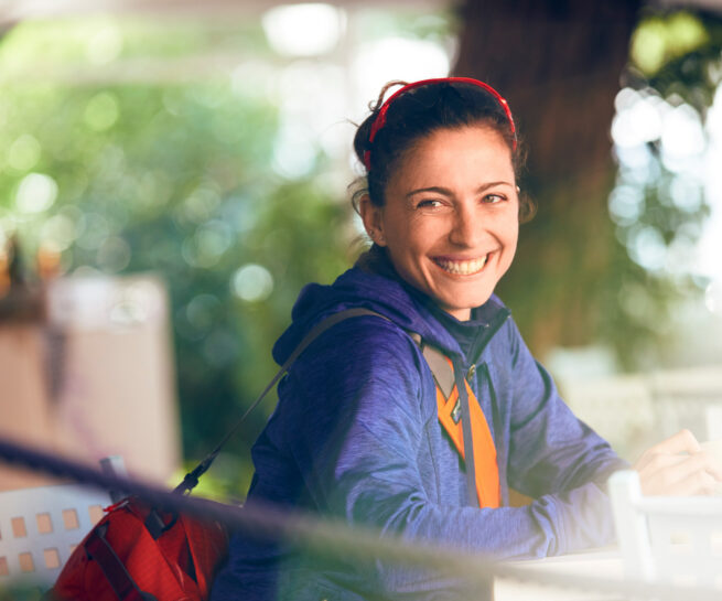 Fotografia ritratto di ragazza che sorride. indossa abbigliamento sportivo, borsa, occhiali da sole. fotografo sportivo duzimage di David Umberto Zappa, fotografo La Spezia