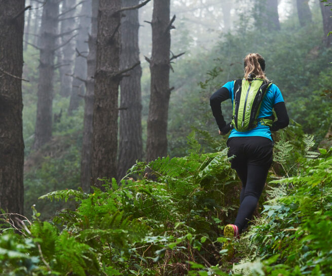 Fotografia di ragazza che pratica trailrunning nel bosco. Scatto realizzato per Polygiene dal fotografo sportivo