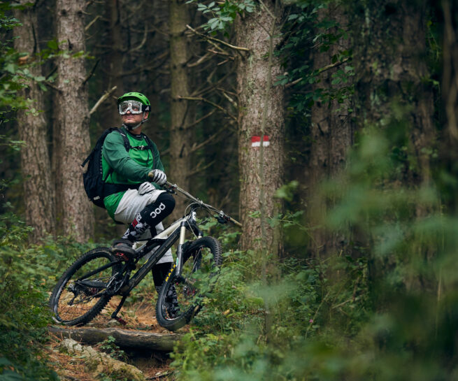 Immagine di biker bicicletta nel bosco mentre si guarda attorno vestito con attrezzatura POC. Immagine sportiva creata per Polygiene dal fotografo duzimage - David Umberto Zappa in provincia di La Spezia