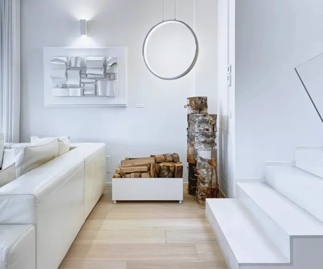 Interior design, immagine di un salotto con divano e scale monocromatico bianco. Elementi in legno: tronco e parquet. Immagine realizzata dal fotografo immobiliare duzimage La Spezia per agenzia immobiliare TheDreamRe Forte dei Marmi